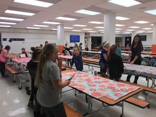 people around a table with a cloth on it